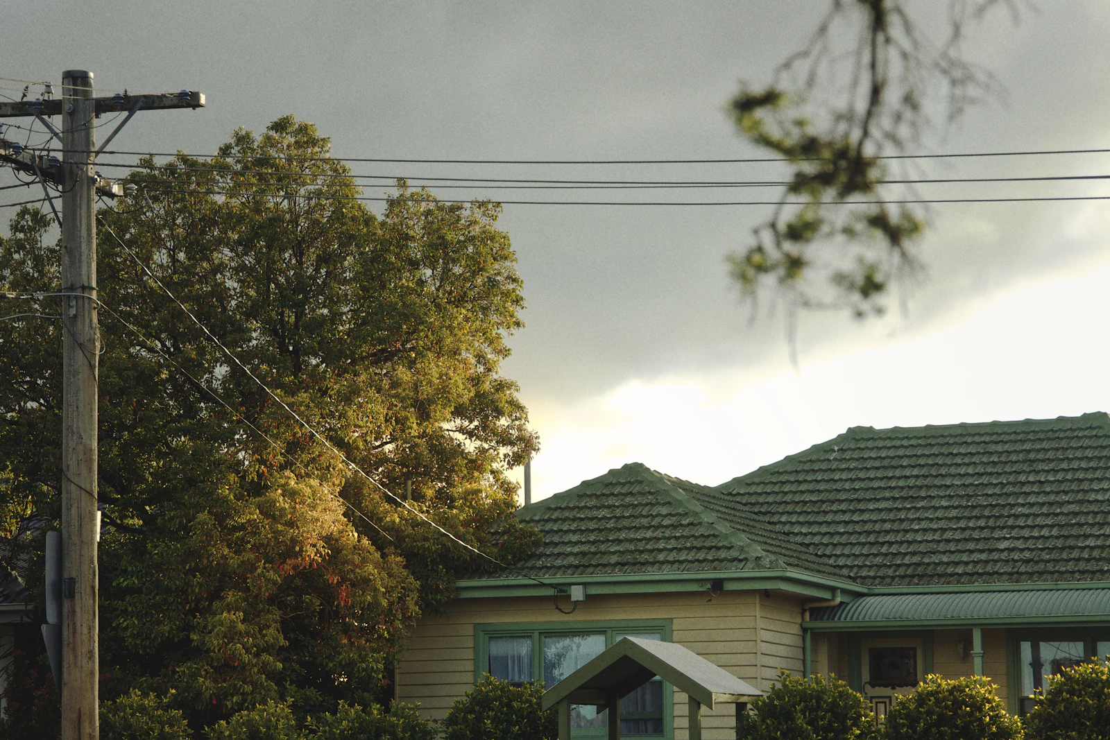 Tiled house roof beneath gathering clouds