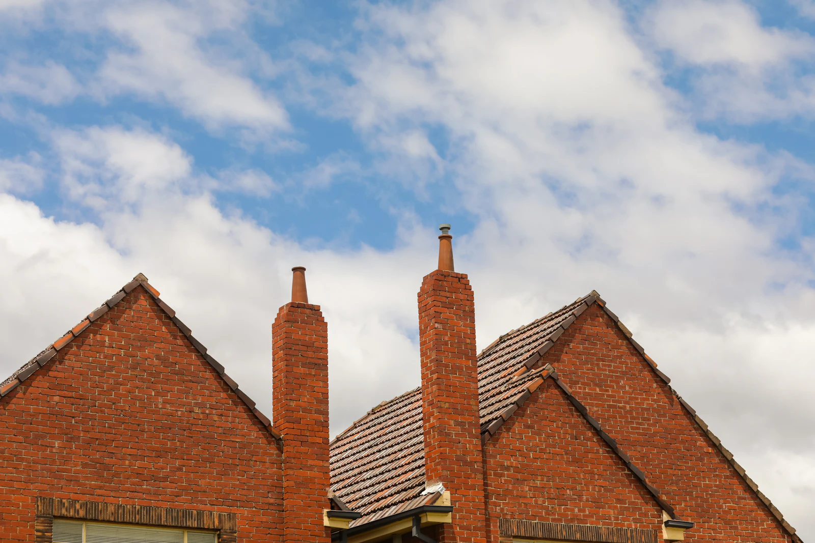 Brick houses with tiled roofs beneath a cloudy sky